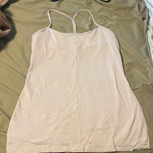 A tank top that is a light pink with a bra inside